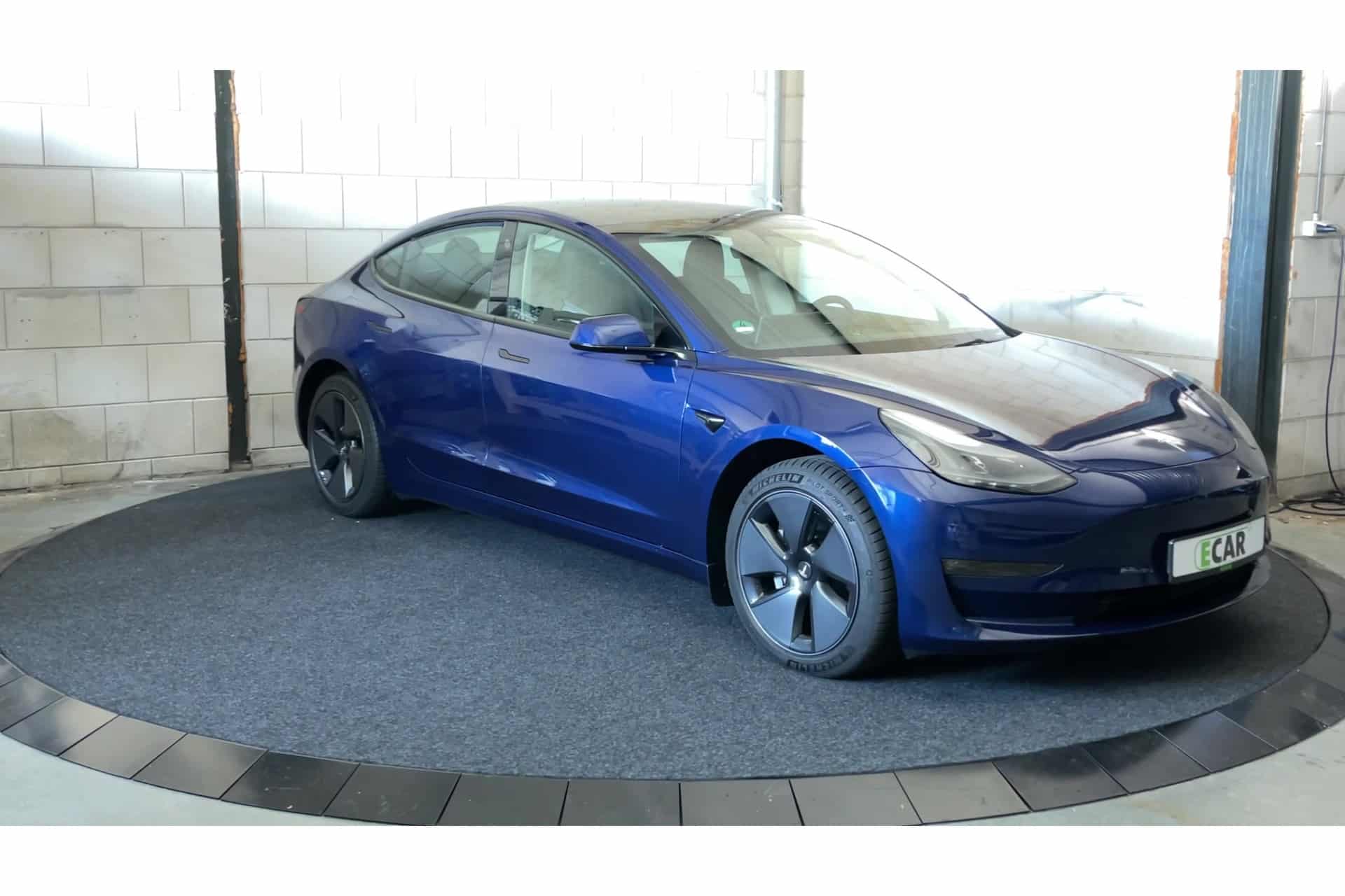 Foto van een Tesla model 3 in het blauw